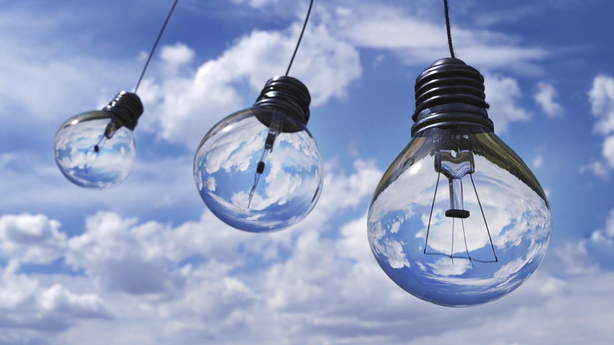 three light bulbs hanging from a cable, with the blue sky in the background