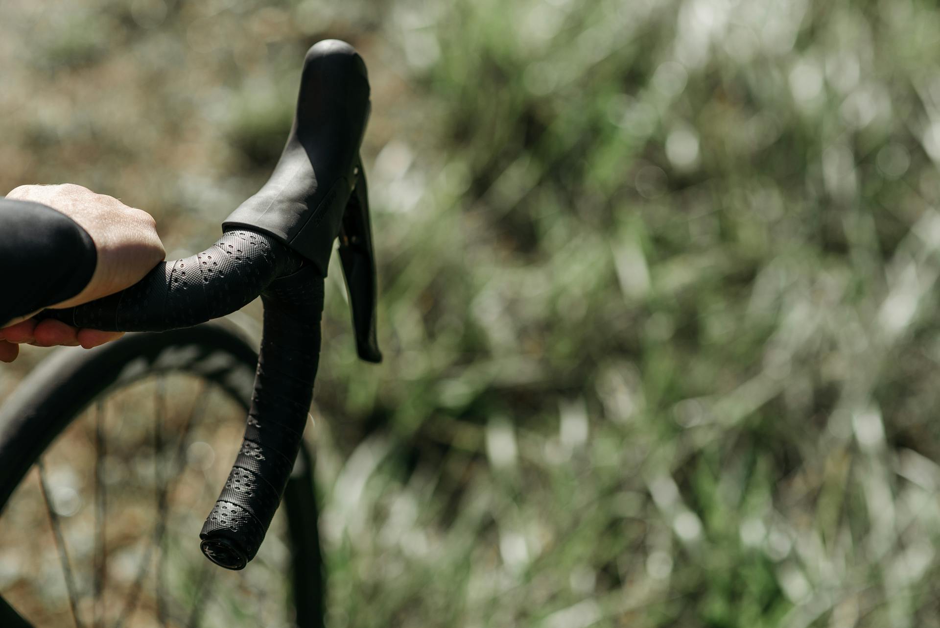 handlebars and wheels of a gravel bike used for racing on grass